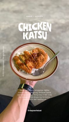 a person holding a plate with food on it and the words chicken katsuu