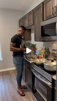 a man standing in a kitchen preparing food on top of a stove next to an oven