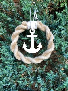 an ornament hanging from a tree with rope and anchor in the shape of a circle