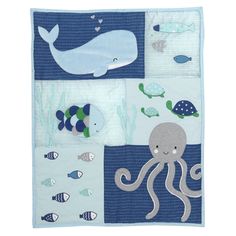 a blue and white blanket with an octopus, whale, fish, and other sea creatures