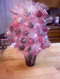 a vase filled with chocolate covered candies on top of a wooden table