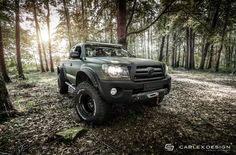 a green truck is parked in the woods