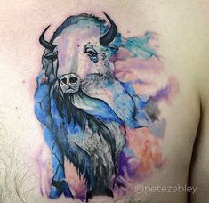 a man's chest with a watercolor bison tattoo on it