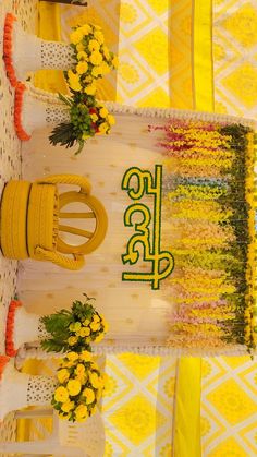 the table is decorated with yellow flowers and green letters on it, along with other decorations