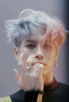 a man with blonde hair and piercings on his fingers