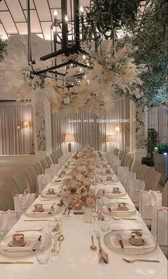 a long dining table with white linens and place settings