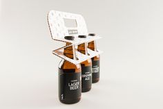 three brown beer bottles sitting next to each other on top of a white countertop