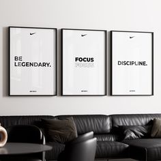 three black and white posters hanging on the wall above a leather couch in a living room