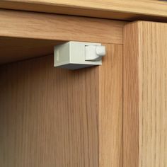 an electronic device is attached to the side of a wooden cabinet