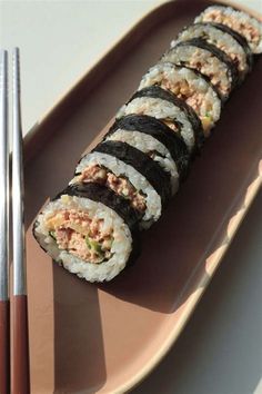 a plate with sushi and chopsticks on it