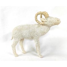 a white sheep figurine with long horns on it's head and tail