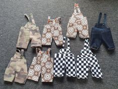 several pairs of overalls are laid out on the floor