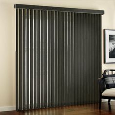 a living room with wooden floors and black vertical blinds