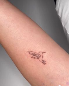 a small hummingbird tattoo on the arm