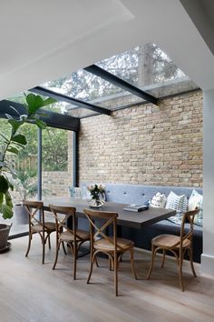 a living room with a couch, table and chairs next to a large glass window