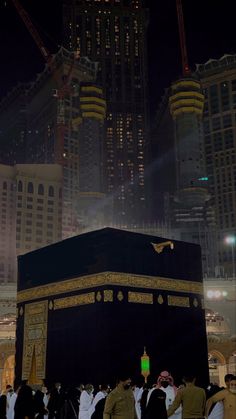 a group of people standing around the kabab in front of some tall buildings