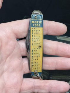 a person holding a miniature morse code in their hand