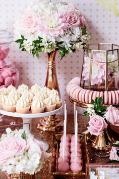 a pink and gold dessert table with lots of cupcakes