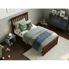 a bed room with a neatly made bed next to a night stand and dressers