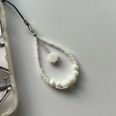 a white beaded necklace next to a plastic container