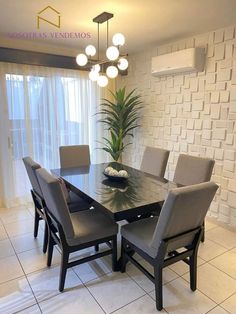 a dining room table with chairs and a potted plant in the middle of it