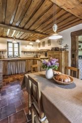 a table with a bowl of flowers on top of it next to a kitchen counter