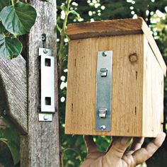 a person holding up a wooden box with metal latches on it's sides