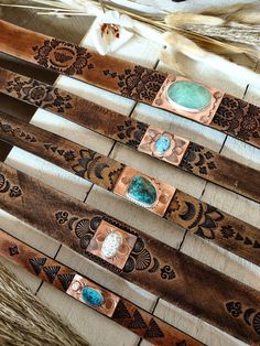 several wooden pieces with different designs on them sitting next to some feathers and other items