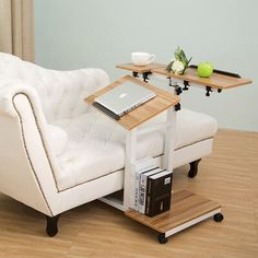 a white couch sitting next to a wooden table on top of a hard wood floor