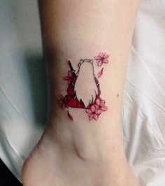 a woman's foot with a small tattoo of a dog and flowers on it