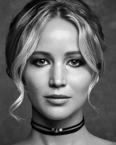 a black and white photo of a woman with blonde hair wearing a choker necklace