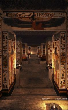 an egyptian style hallway with columns and paintings on the walls, lit up by candles