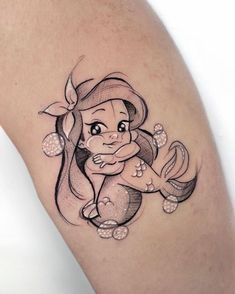 a woman's leg with a little mermaid tattoo design on it and the word disney written