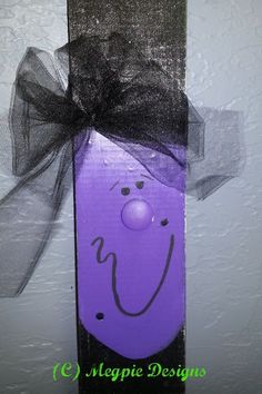 a purple face with a black bow on it