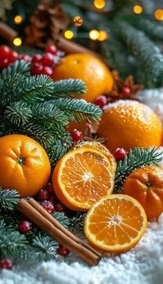 an arrangement of oranges, cinnamon sticks and christmas decorations