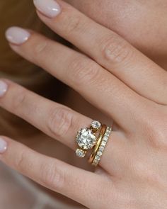 a woman's hand with two rings on her fingers and one ring in the middle