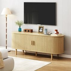 a flat screen tv mounted to the side of a wooden cabinet in a living room