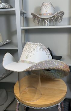 If a discount is present, it applies only to clear and clear ab stones. All other colors will have a surcharge after purchase.   I want to point out that each hat is hand-crafted. They are not without blemishes and there are no refunds as each hat is custom-made. 1) What date do you need your hat by? 2) If you know your hat size (E.g. 7 1/8) tell us. If not, watch these two YouTube videos. Measure with a SOFT tape.... Youtu.be/AwF7euDtI68 .... Youtu.be/WlDH956DMuI -Add rhinestone text for $7 per letter. Add vinyl text or logo. Price is dependent on design. Primary color= Stone color. Secondary= Hat color. Shop link for more products- www.etsy.com/shop/RhinestoneRodeo7 White Party Hat With Rhinestones, Fringe Cowgirl Hat, Rhinestone Cowboy Hat, Space Costume, Bridesmaids Outfits, Space Costumes, Wedding Country, Space Cowboys, Rhinestone Crown