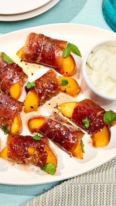 bacon wrapped in peaches and garnished with mint leaves on a white plate