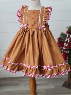 Girls Gingerbread Dress Adorable girls Gingerbread Dress! Features fun trim and ties in back. Gingerbread Christmas Dress, Fitted Ruffle Holiday Dress For Dress-up, Fitted Ruffle Holiday Dress For Dress-up Events, Formal Fitted Ruffle Holiday Dress, Sleeveless Ruffled Holiday Dress, Christmas Sleeveless Ruffled Holiday Dress, Christmas Sleeveless Ruffle Holiday Dress, Sleeveless Ruffled Christmas Holiday Dress, Sleeveless Ruffled Holiday Dress For Christmas