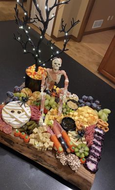 a wooden tray filled with halloween food on top of a table next to a tree