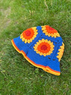 a crocheted sunflower hat laying on the grass