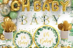 a baby shower with balloons, plates and gold confetti on the table in front of it