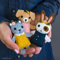 a person holding three small stuffed animals in their hands