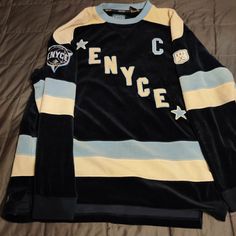 an old hockey jersey with the name nycfc on it is laying on a bed