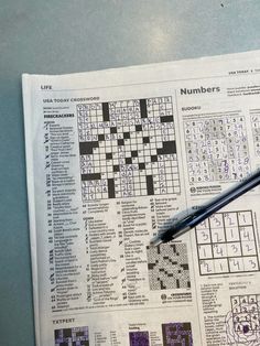 a crossword puzzle on top of a newspaper