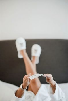 a woman laying on top of a bed with her feet up