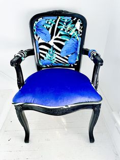 a blue and black chair sitting on top of a white floor next to a wall