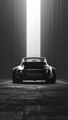 a black and white photo of a car parked in an empty room with light coming through the window