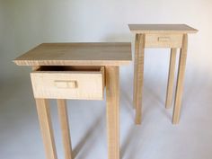 two wooden tables sitting side by side on a white surface with one drawer open and the other closed